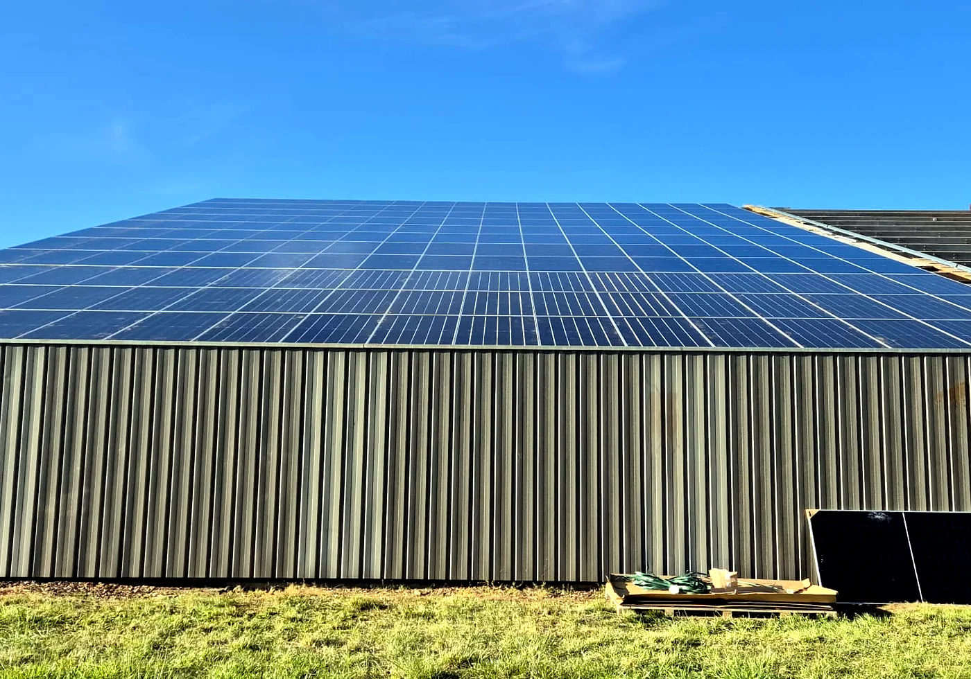 Gro&szlig;e Industriehalle mit installierten Solarmodulen